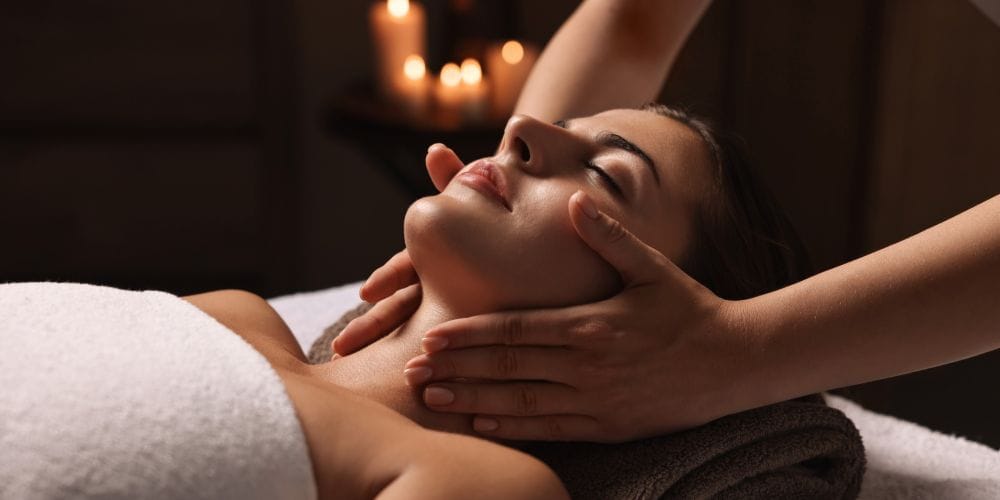 Woman getting a face massage at a day spa.